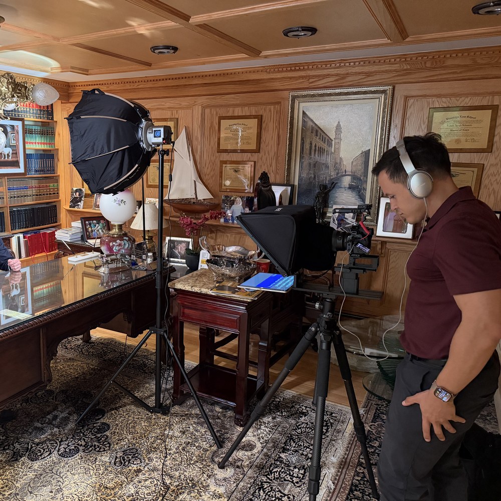 Derick Waller directing a video production shoot, wearing headphones behind the camera